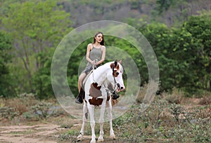 Women on skirt dress Riding Horses On field landscape Against forest.