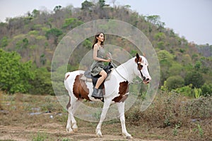 Women on skirt dress Riding Horses On field landscape Against forest.