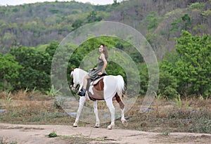 Women on skirt dress Riding Horses On field landscape Against forest.