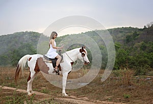 Women on skirt dress Riding Horses On field landscape Against forest.