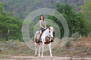 Women on skirt dress Riding Horses On field landscape Against forest.