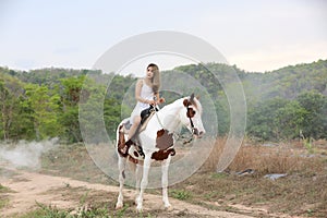 Women on skirt dress Riding Horses On field landscape Against forest.