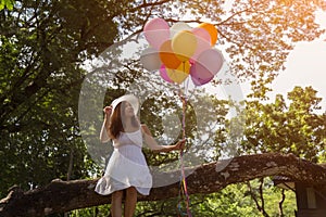 Women are smiling, sitting holding a transparent ball under the tree. photo