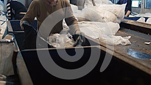 Women sorting by hands household waste for further trash recycling