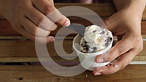women spoon spick ice cream from a cup