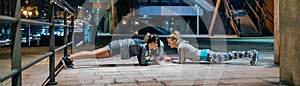Women sport team doing plank exercise during training on the city at night