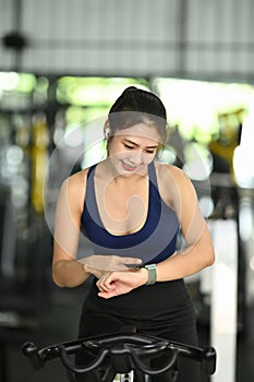 Women in sportswear checking pulse on her smart watch.