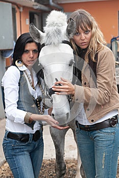 Women in a stable before riding her horse