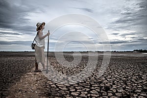 Women standing on dry soil and fishing gear, global warming and water crisis