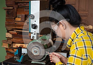 Women standing is sharpen drill at a work bench with  Whetstone Machine