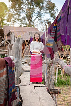 Women are standing watching the beautiful fabric on bamboo bridge in the field at Pua district