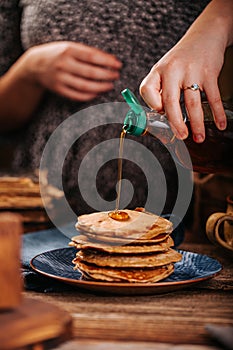 Women stream delicious mapple syrup for home made american pancakes