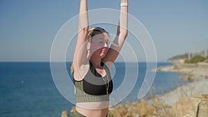 Women stretching arms and legs while practicing yoga at seashore