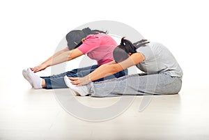 Women stretching legs and arms at gym