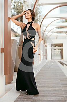 Women Style. Fashion Girl In Long Black Dress Posing Outdoors