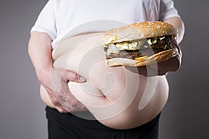Women suffer from obesity with big hamburger in hand. Junk food concept