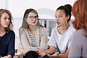 Women supporting each other during psychotherapy group meeting photo