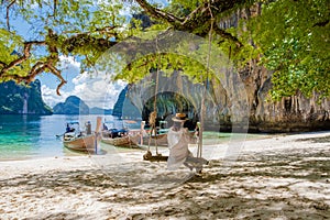 women on a swing at the Tropical lagoon of Koh Loa Lading Krabi Thailand part of Koh Hong Islands