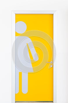 Women symbols on yellow public toilet entrance door.