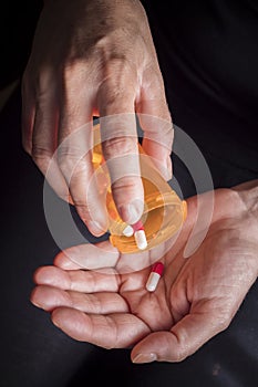Women take white and red capsule with right hand from a ambar photo