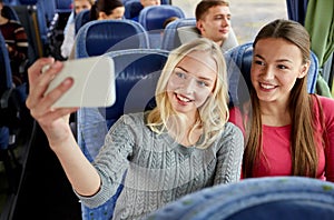 Women taking selfie by smartphone in travel bus