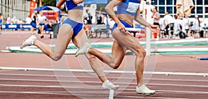 women team running relay race in track stadium summer athletics