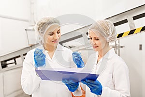 Women technologists tasting ice cream at factory