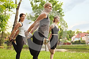 Women and teenage girl doing morning exercise in park