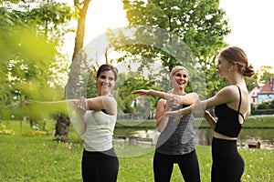 Women and teenage girl doing morning exercise in park