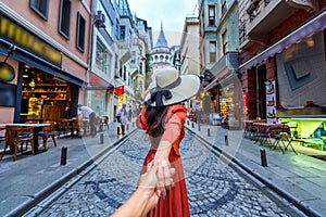 Women tourists holding man`s hand and leading him to Galata tower in Istanbul, Turkey. photo