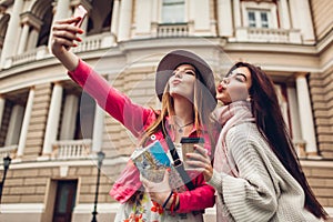 Women tourists taking selfie going sightseeing in Odessa. Happy friends travelers having fun