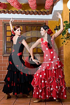 Women in traditional flamenco dresses dance during the Feria de Abril on April Spain photo