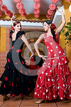 Women in traditional flamenco dresses dance during the Feria de Abril on April Spain photo