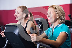 Women training on exercycle in gym-hall