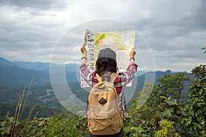 Women traveler with backpack checks map