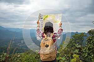 Women traveler with backpack checks map photo