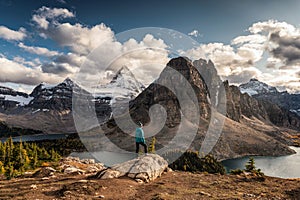 Women traveler standing on cliff with Mount Assiniboine on Niblet in provincial park