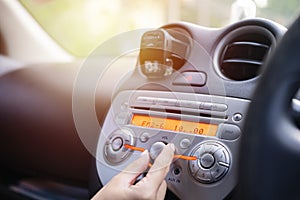 Women turning button on car radio
