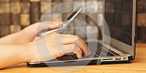 women typing on keyboard of modern laptop and holding classic ancient clapet phone.