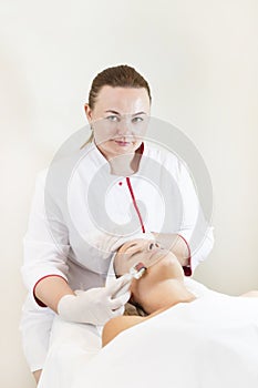 The woman undergoes the procedure of medical micro needle therapy photo
