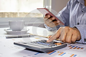 Women use calculators to calculate annual reports, including notebooks on wooden desks for work, work concepts.