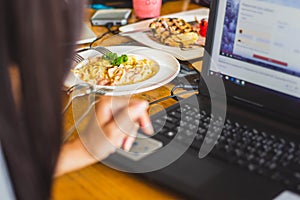 Women using laptop cafés working on her laptop computer. focus food restaurant