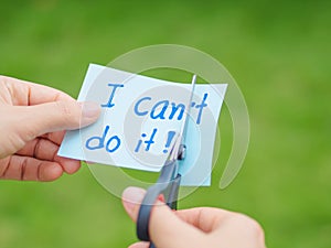 Women using scissors to remove the word can`t to read I can do it concept for self belief, photo