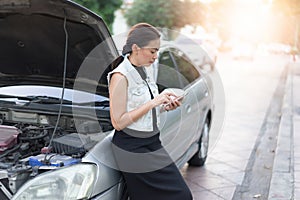 Women using smartphone to call a car mechanic.