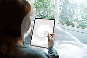 Women using tablet on bed in morning