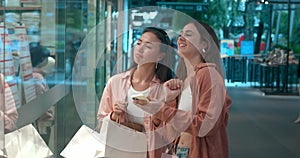 Women viewing storefronts in mall side view discussing shopping Storefronts showcase fashion joy. Storefronts mirrors of