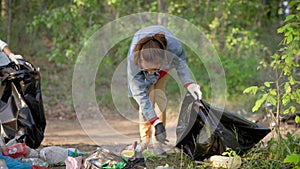 Women volunteers liquidate a large landfill. Illegal landfill in the forest spoils nature and ecology. Volunteers make