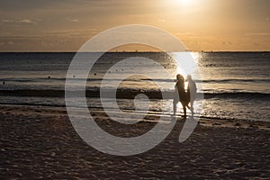 Women Walking Along the Beach at Sunrise