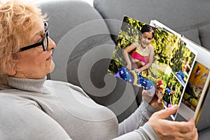 Women watching family album at home, elderly woman watching photobook