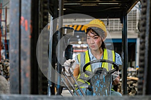 Women wear safety helmet driver forklift warehouse in factory. Female worker industrial operate. control loading container box.